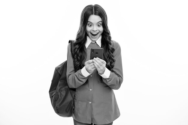 Excited face Teen student girl hold backpack use mobile cell phone on white background Education