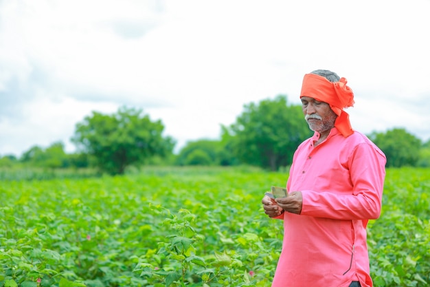 Excited farmer holding Indian rupee notes