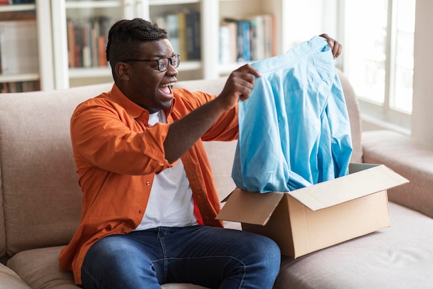 Excited fat african man customer checking delivery good parcel