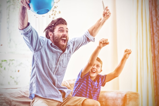 Excited father and son watching television