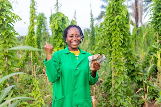 いくらかのお金を持っているナイジェリアの興奮した女性のアフリカの農夫