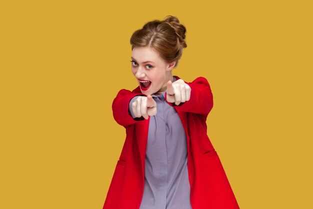 Excited flirting woman with red lips pointing at you looking at camera with positive expression