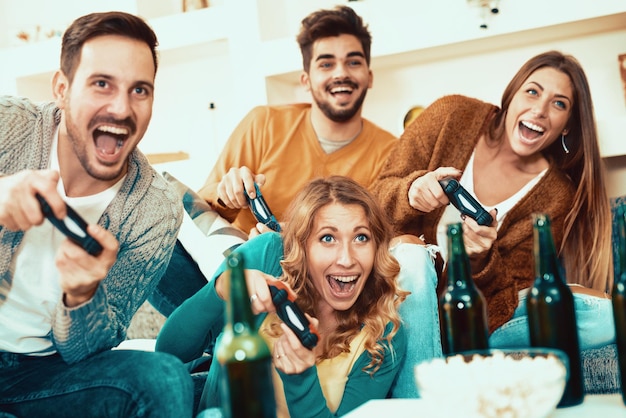 Excited friends playing video games at home