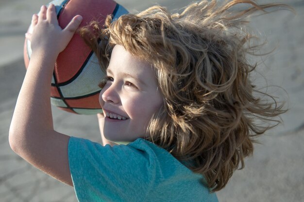 Excited funny kid playing basketball closeup child portrait funny child sporty face cute smiling boy...