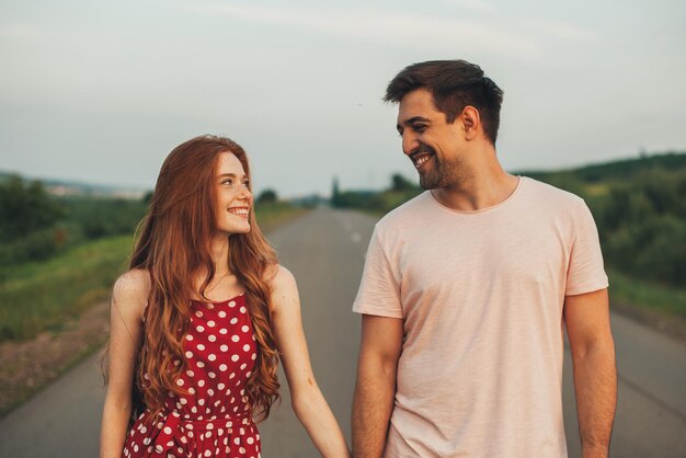 Excited girl and boy having their first date smiling and looking at each other as they walk along th...