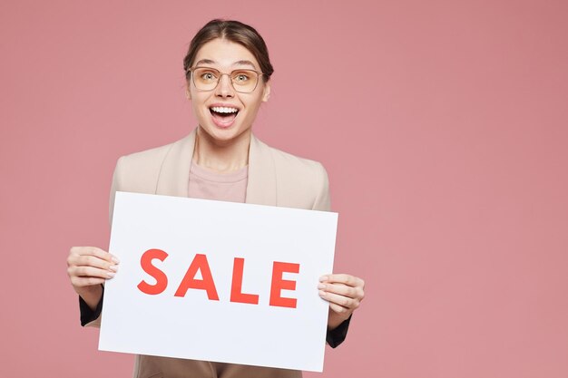 Excited girl with sale banner