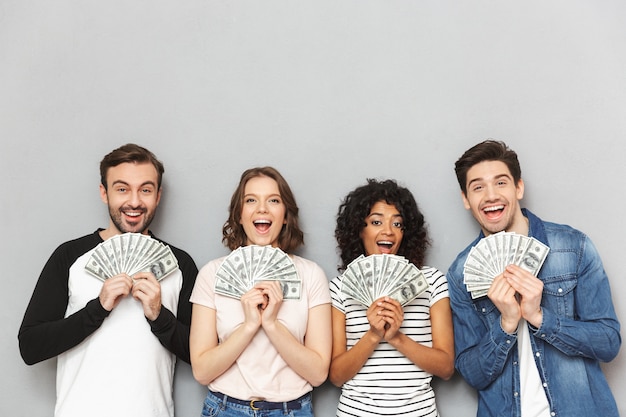 Photo excited group of friends holding money.