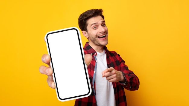 Возбужденный парень указывает на белый пустой экран смартфона