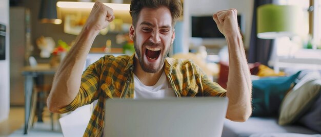 Photo an excited handsome man working on a laptop a freelancer working from his living room has a stroke of luck and wins big