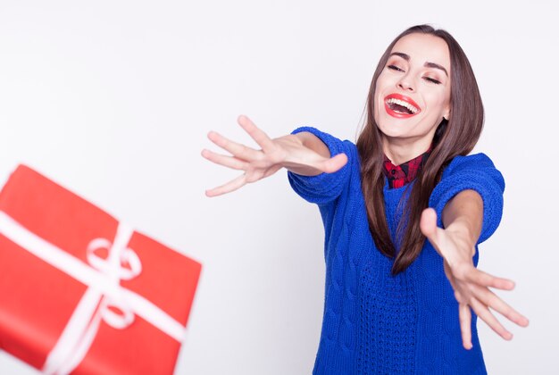 Foto la donna carina eccitata e felice tiene una grande confezione regalo e si diverte