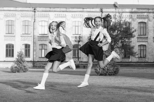 Excited happy girls school uniform running hurry up concept