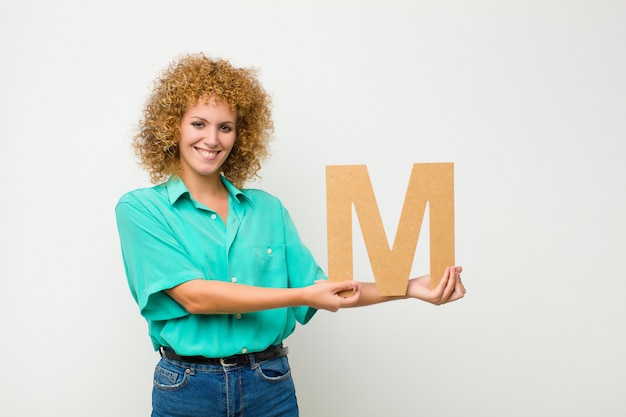 excited, happy, joyful, holding the letter M of the alphabet to form a word or a sentence.