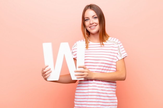 excited, happy, joyful, holding the letter W of the alphabet to form a word or a sentence.