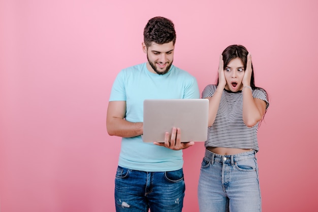 Giovani uomo e donna sorridenti felici emozionanti delle coppie insieme al computer portatile