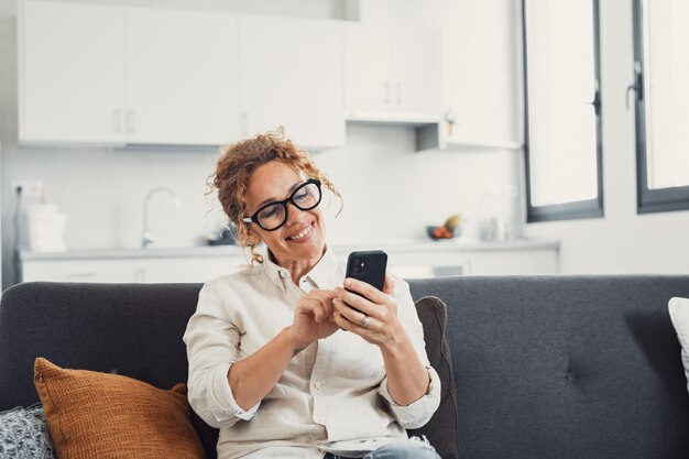 Photo excited happy young adult woman reading message on mobile phone getting good news