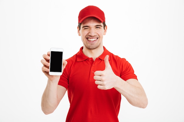 Excited happy young delivery man make thumbs up gesture.