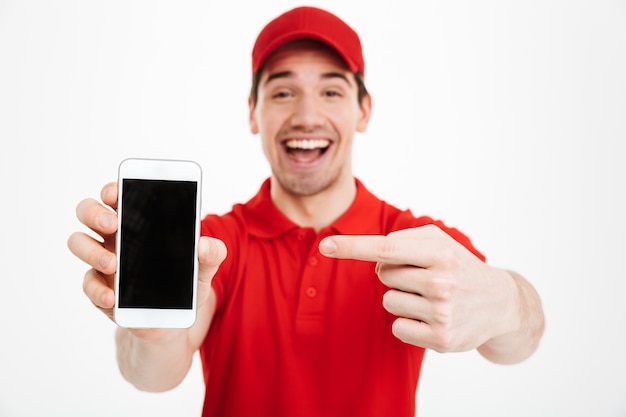 Excited happy young delivery man showing display of mobile phone.