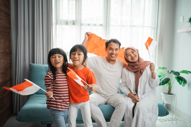 Excited indonesian family supporter while watching sport match at television at home together