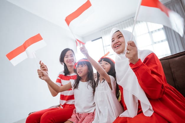 Excited indonesian family supporter while watching sport match at television at home