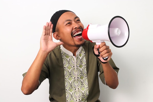 Foto un uomo indonesiano eccitato promuove il ramadan con un megafono