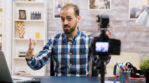 Excited influencer while recording for his vlog in living room. Famous creative man.