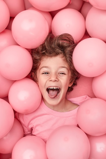 Excited kid playing in balloons