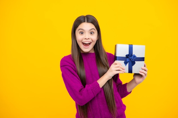 Excited kids face Child with gift present box on isolated background Presents for birthday Valentines day New Year or Christmas Amazed expression cheerful and glad