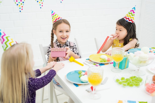 Excited little girl receiving gifts from friends