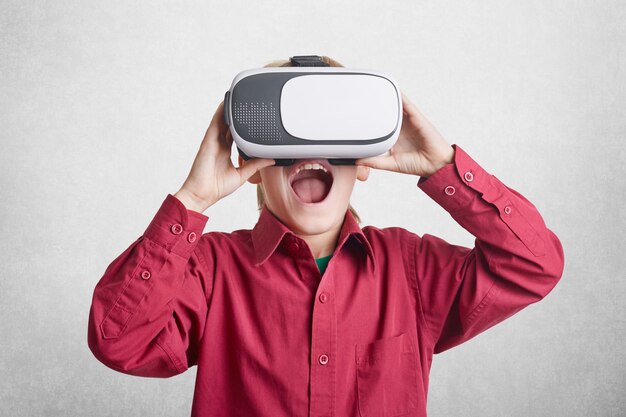 Excited male kid wears virtual reality