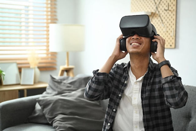 Excited man experiencing virtual reality while using virtual reality headset for entertaining