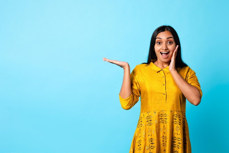 फोटो excited middle eastern woman in traditional dress advertising product studio