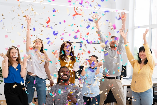 Photo excited people celebrating with confetti