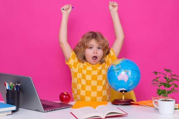 Excited pupil nerd school kid isolated on studio background\
clever child from elementary school with book smart genius\
intelligence kid ready to learn hard study