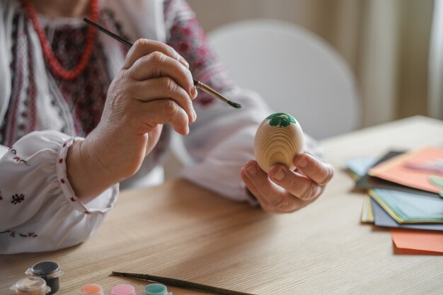 Excited retired old man painted easter egg. DIY craft easter eggs