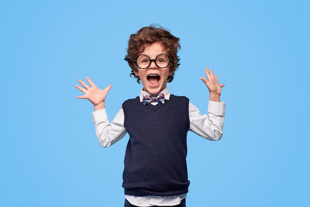 Photo excited schoolboy screaming and gesturing with hands