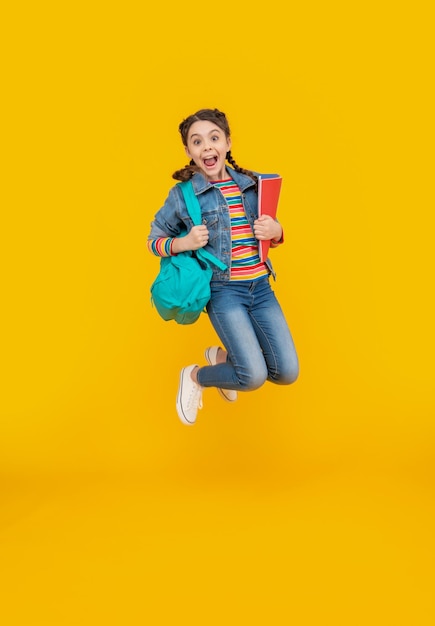 Excited schoolgirl screaming in midair school Energetic girl jumping after school