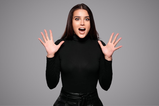 Excited screaming woman with fascial emotions standing isolated over grey isolated background. High quality photo