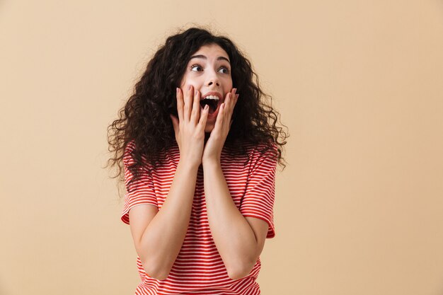 Excited shocked young woman looking aside.