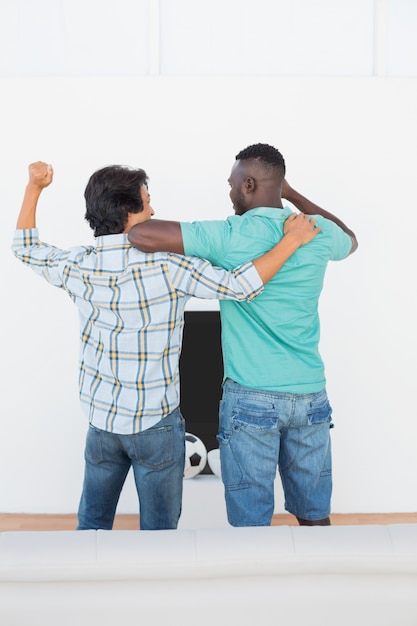 Excited soccer fans watching tv