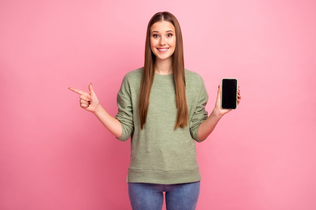 Excited stylish girl hold cellphone indicate point finger copyspace