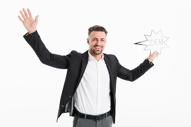 excited successful man wearing black jacket rejoicing and holding speech bubble with word idea in hand, isolated over white