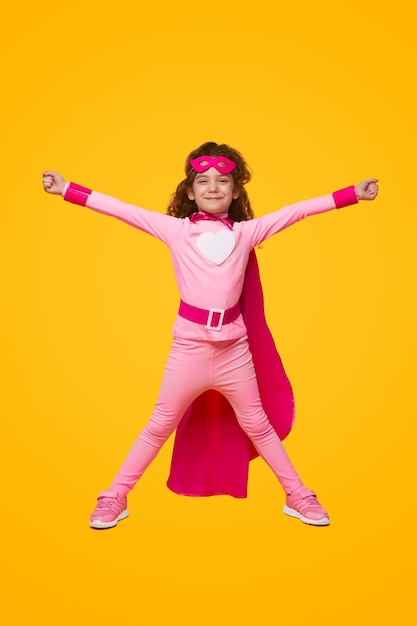 Взволнованная девушка-супергерой с поднятыми руками