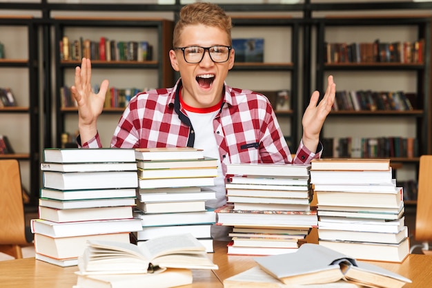 Excited teenage boy sitting at the library