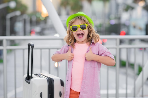 Excited tourist funny child traveller child with travel suitcase on vacation kids travelling