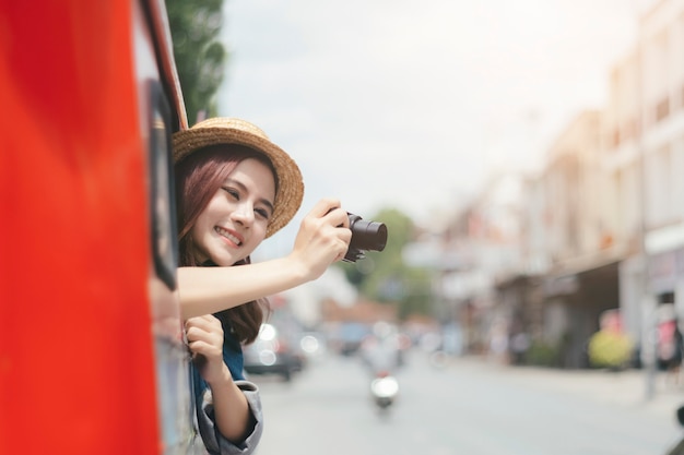 Excited tourists are taking pictures while sitting on the car. 