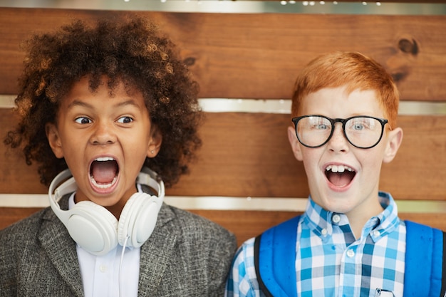 Photo excited two schoolboys outdoors