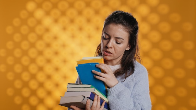 Foto donna eccitata che sfoglia un mucchio di libri scegliendo cosa leggere