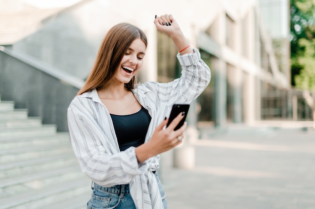 電話で彼女の勝利について幸せな興奮した女性