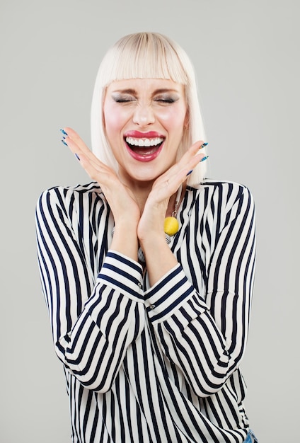 Excited Woman holds cheeks by hand Beautiful girl with bob hairstyle surprised and shocked Expressive facial expressions businesswoman