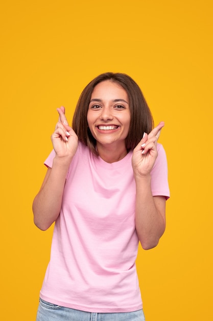 Excited woman making wish with crossed fingers